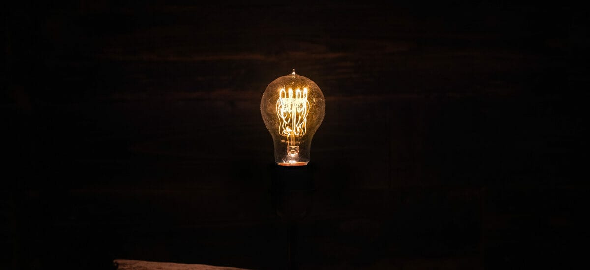 lightbulb lit in a dark room, signifying digital marketing