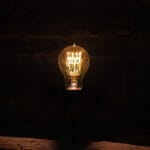 lightbulb lit in a dark room, signifying digital marketing