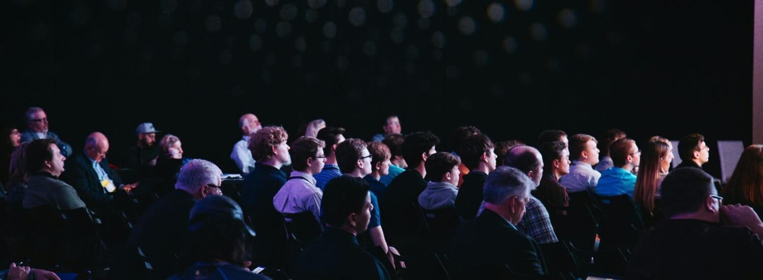 Conference attendees watching presentation in dark room