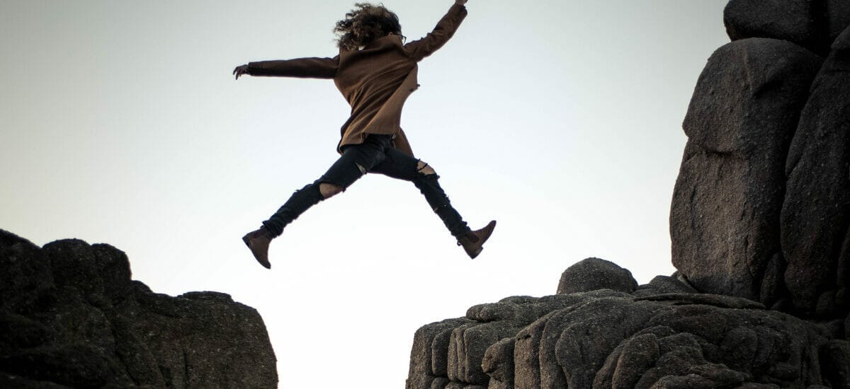 A person leaping from one cliff to another, signifying a quantum leap in technology